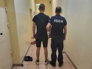 zatrzymany mężczyzna stoi  z policjantem