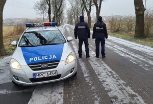 policjanci stoją przy samochodzie