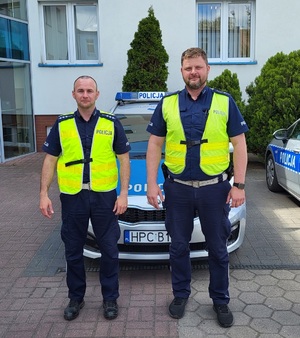 policjanci stoją przy radiowozie