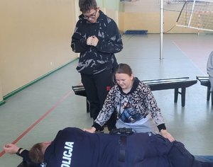 policjant uczy jak udzielać pierwszej pomocy