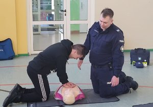 policjant uczy jak udzielać pierwszej pomocy